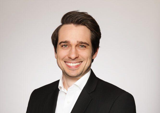 Professional headshot of a smiling Furfolk co-founder in business attire against a light background.