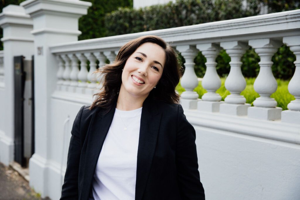 Smiling Furfolk co-founder Ashleigh Greene standing by a Brisbane street, specialist in hiring trusted dog walkers and pet sitters.